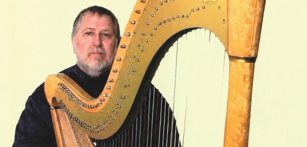 Photo of Bernard Andrès standing with his harp