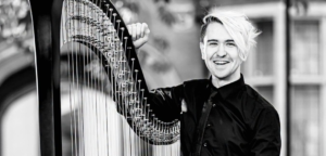 A black-and-white image of Richard Allen standing with his harp